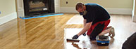 An craftsman refinishes a floor